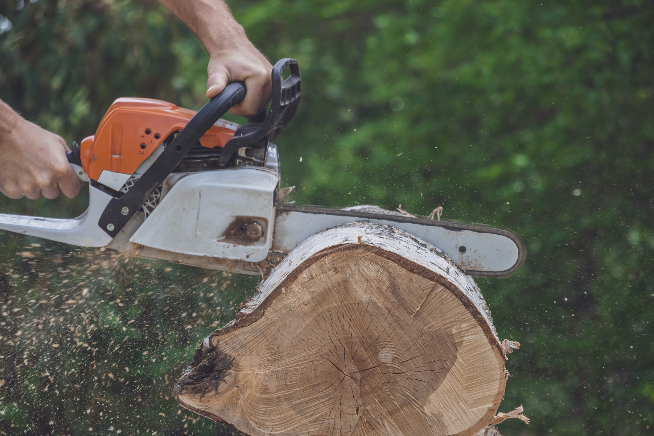 Someone using a chainsaw to cut wood