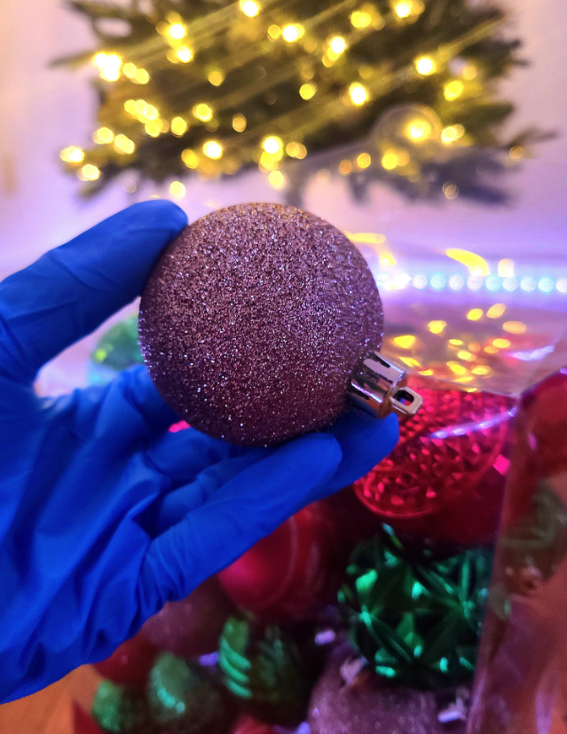 A hand holding a Christmas ornament