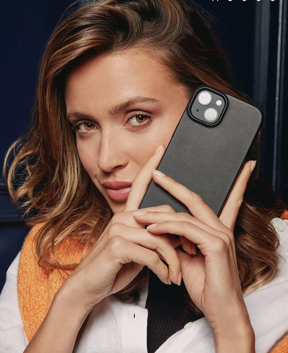 A person holding up a phone in the case
