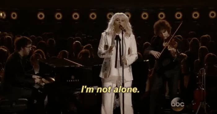 a woman singing saying, &quot;i&#x27;m not alone.&quot;