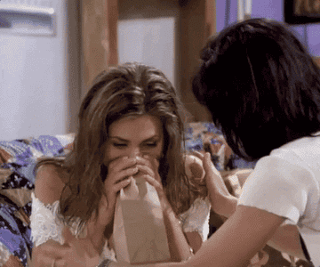 a gif of rachel from friends hyperventilating into a paper bag