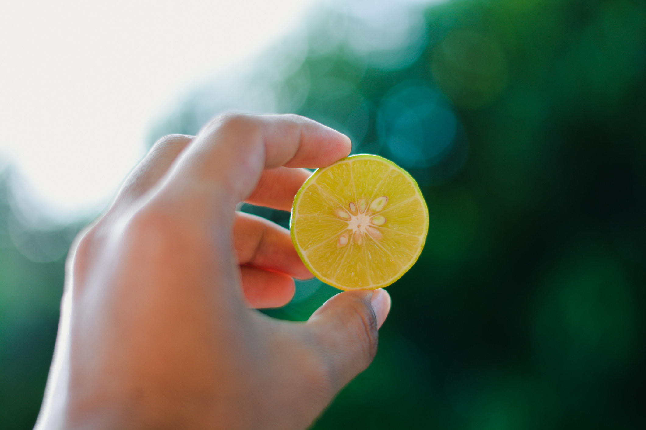 A person holding half a lemon