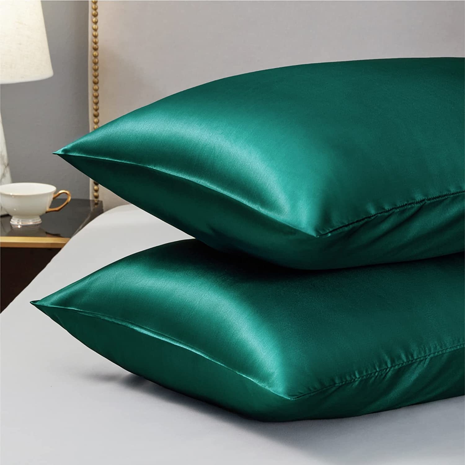 The green pillows are shown on a bed