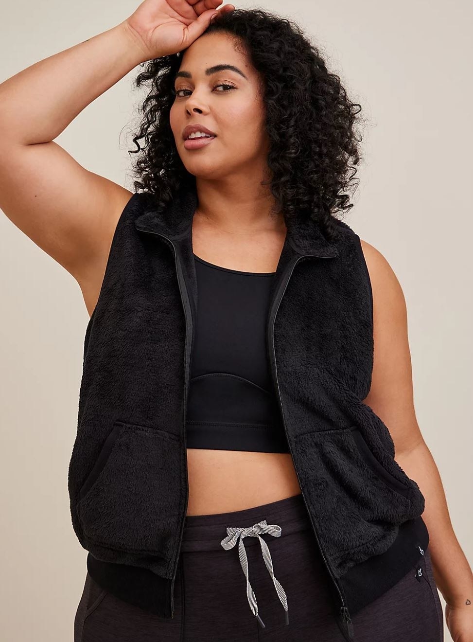 model wearing black faux fur vest