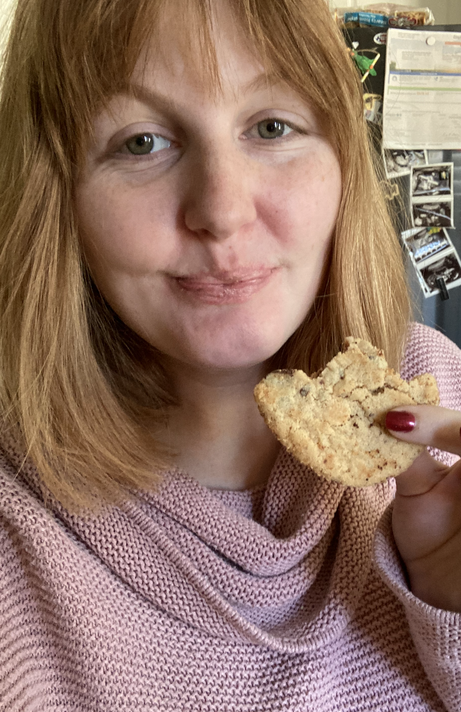 author smiling at the camera holding a cookie