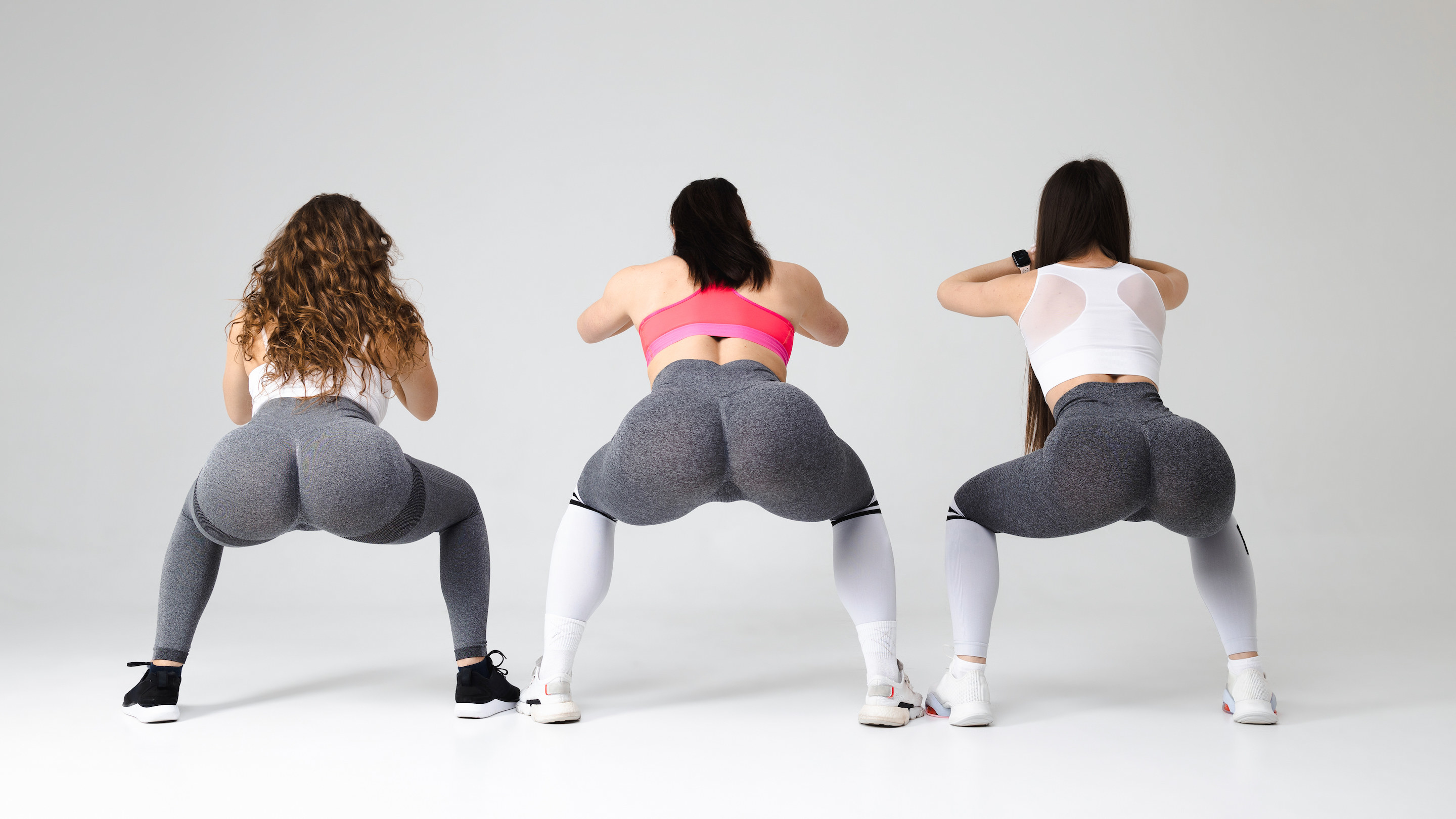 women in tights squatting