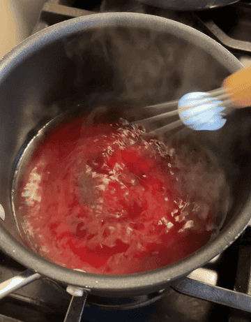 whisking strawberry jello into boiling water