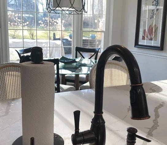 a reviewer photo of the paper towel holder next to a sink faucet