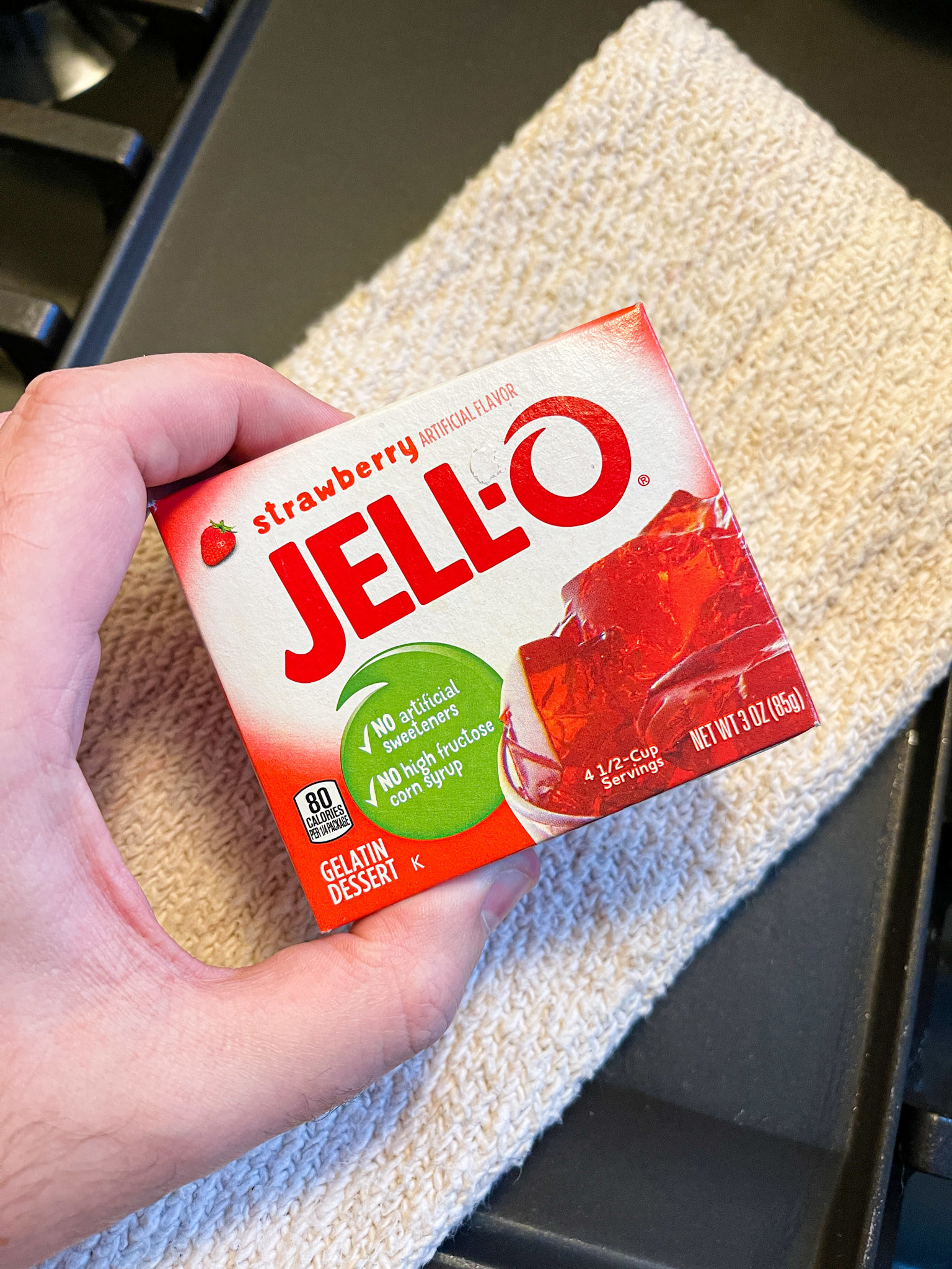 author holding jello pack in front of towel