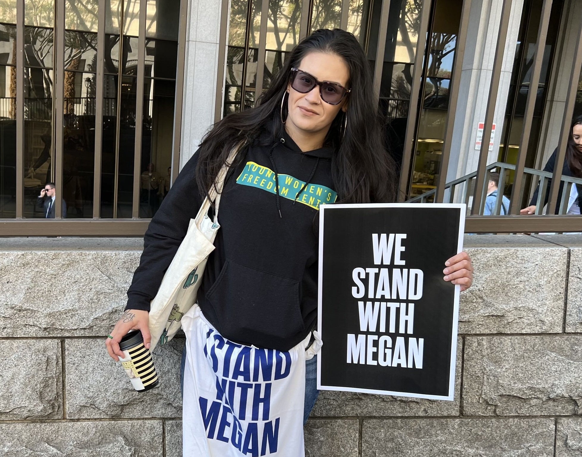 A person holds a sign reading &quot;we stand with megan&quot;