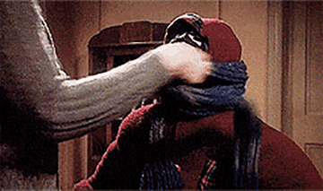 Gif of the mom in a christmas story wrapping up randy in a big scarf