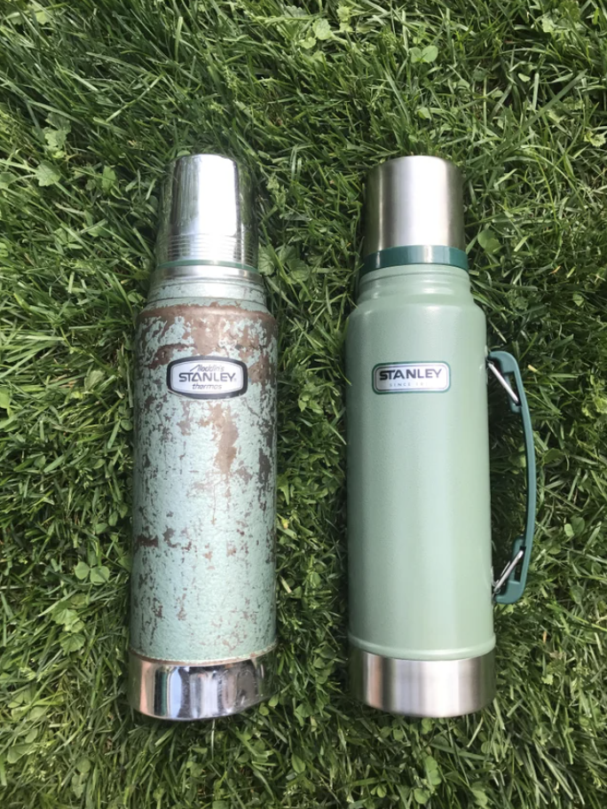Two thermoses on the grass, one rusted, one new