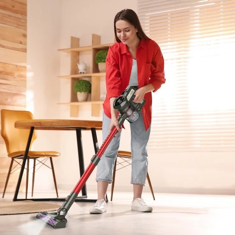Model using red slim stick vacuum