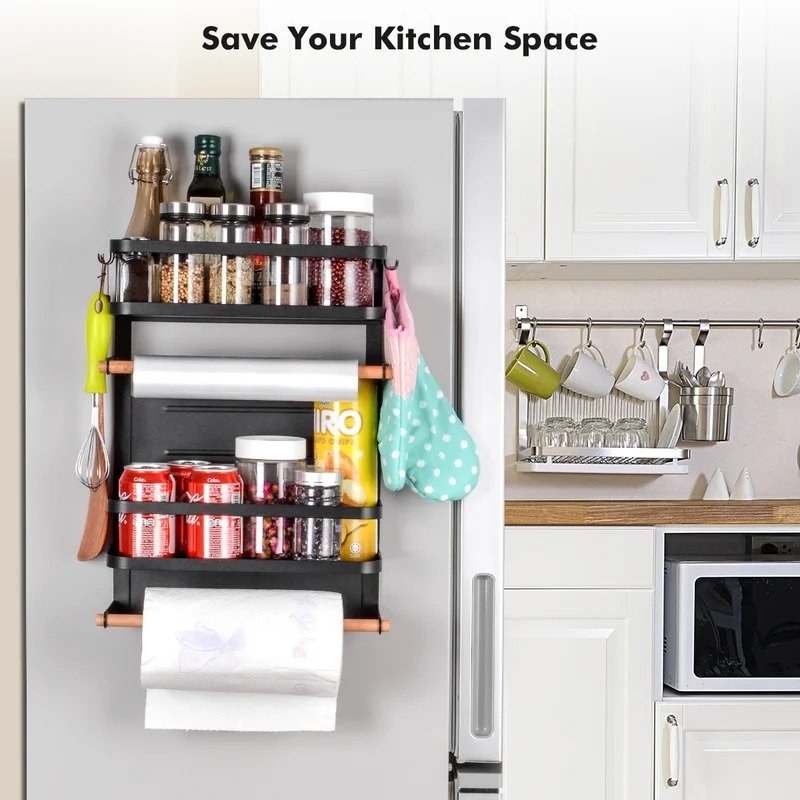 Black magnetic spice rack on fridge, with spices, cannisters, paper towels and saran wrap on towel racks