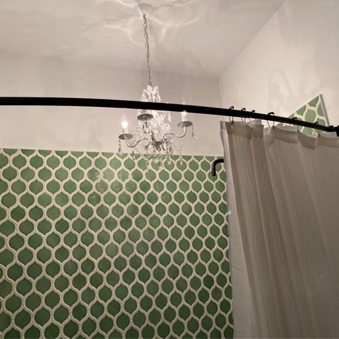 Black rounded shower curtain in green shower