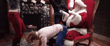 A woman flipping her hair as she gives Santa Claus a lap dance