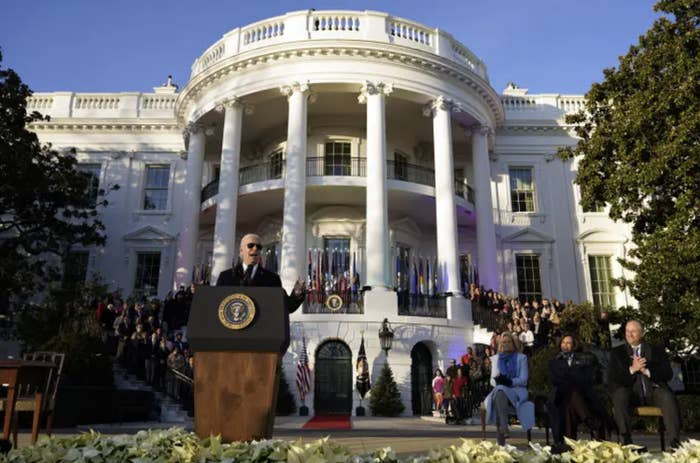 Biden speaking in front of a crowd of people at the White House