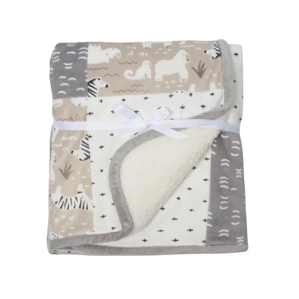 a folded patchwork blanket in muted taupe and gray tied with a ribbon on a white background
