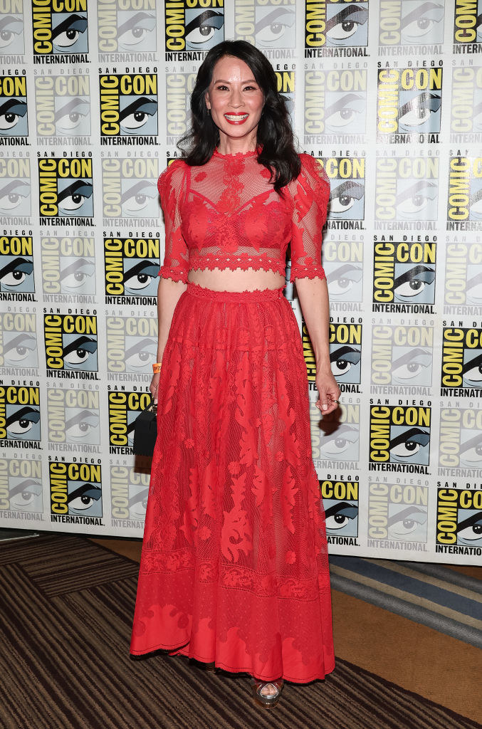 Lucy Liu in a sheer, lacy crop top and matching skirt