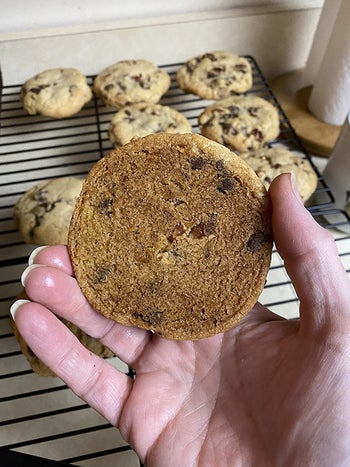 reviewer showing the golden brown, evenly baked bottom of a cookie baked on the silicone baking mat