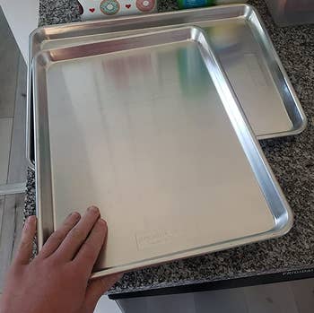 reviewer's hand resting on one of the baking sheets