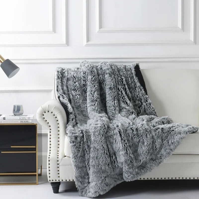 the black ombre throw blanket on a white couch