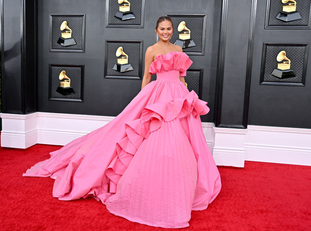 Chrissy Teigen in a flowing off-the-shoulder gown with a long train