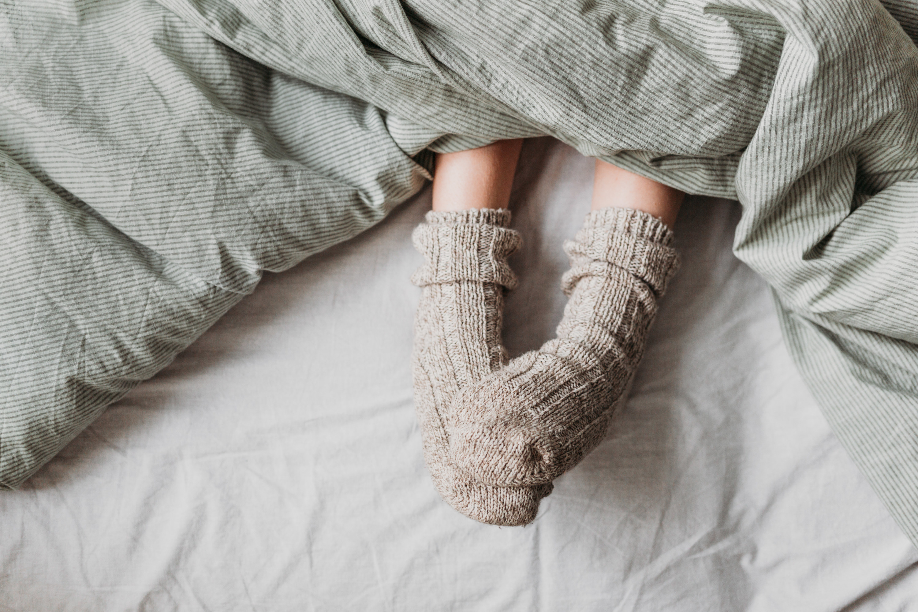 a person with socks on in bed