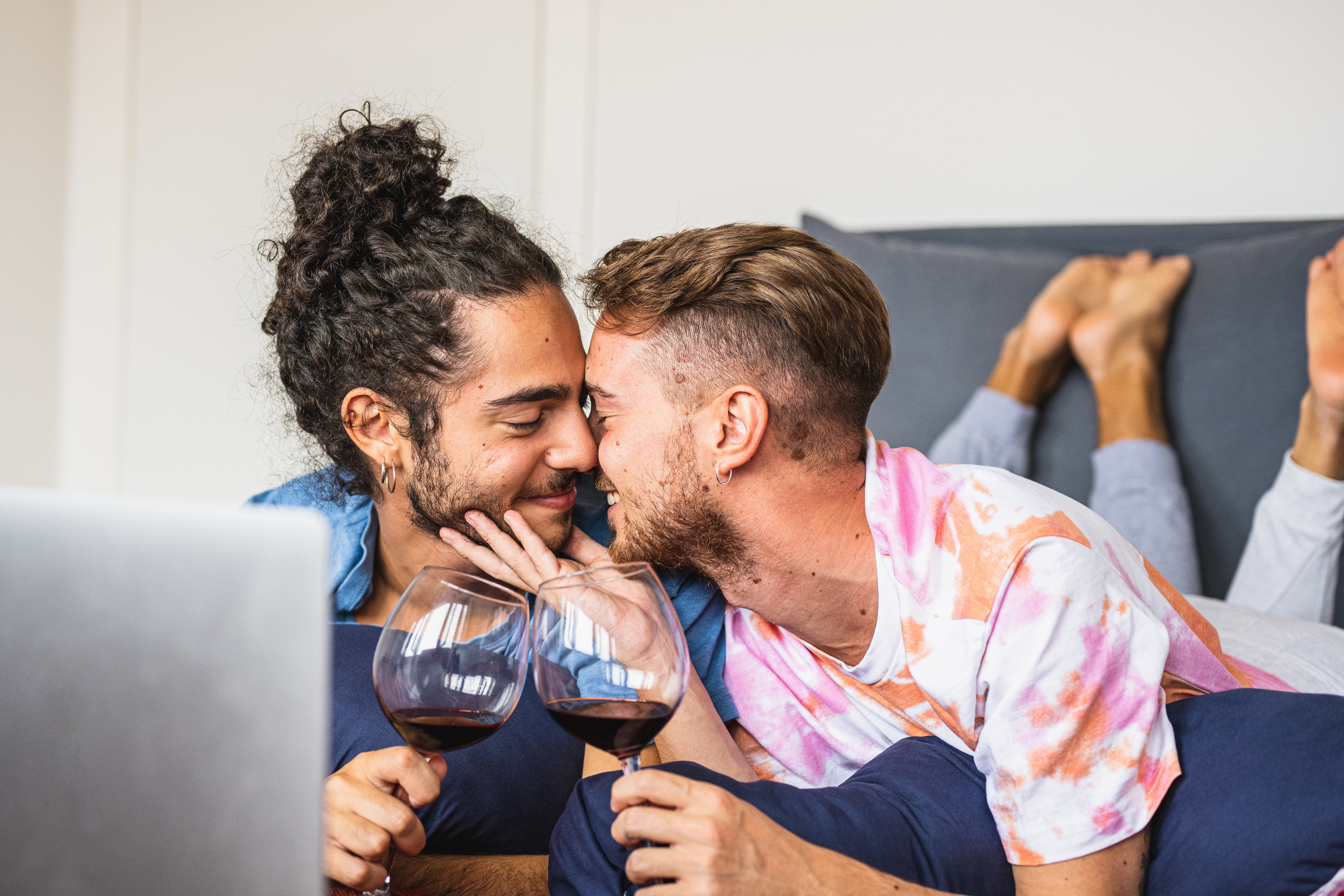 a couple kissing with wine in their hands