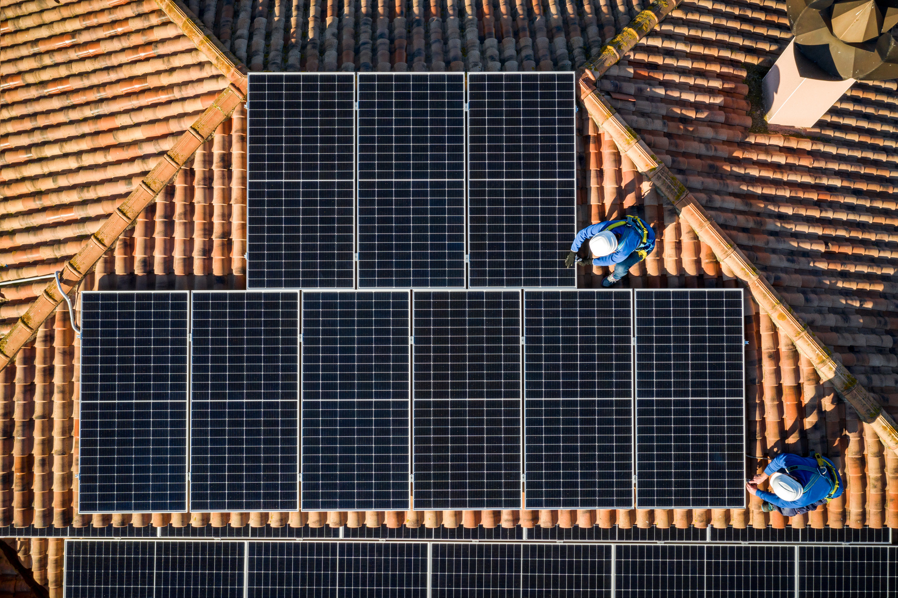 Workers installing solar panels on a rooftop
