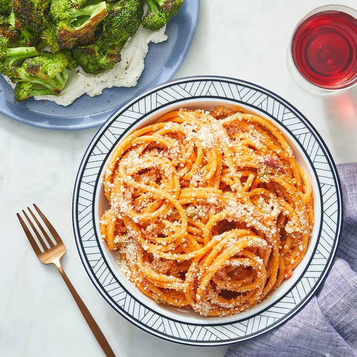 bowl of roasted red pepper pastas topped with Parmesan cheese