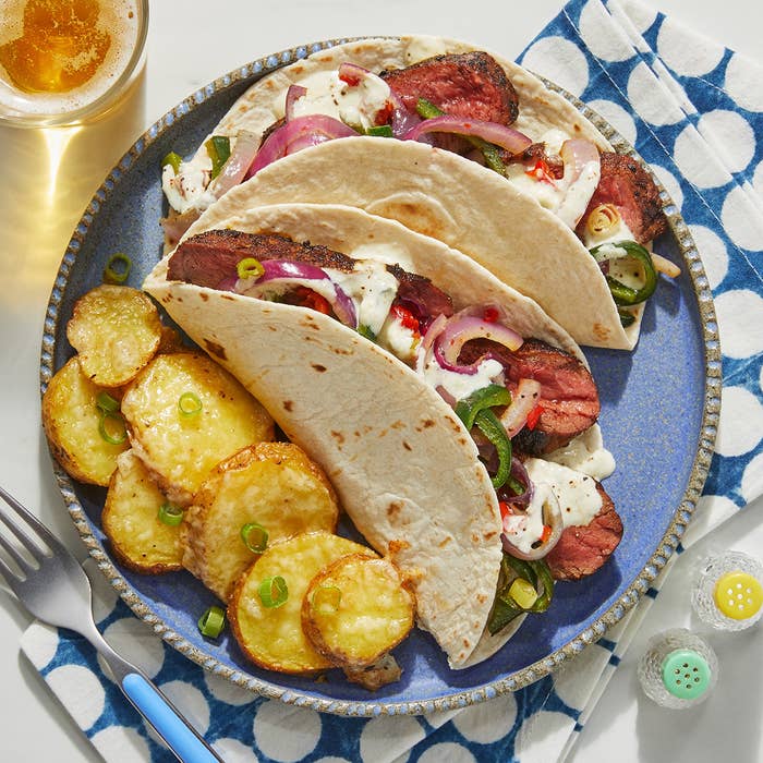 plate with steak tacos and a side of crispy potatoes