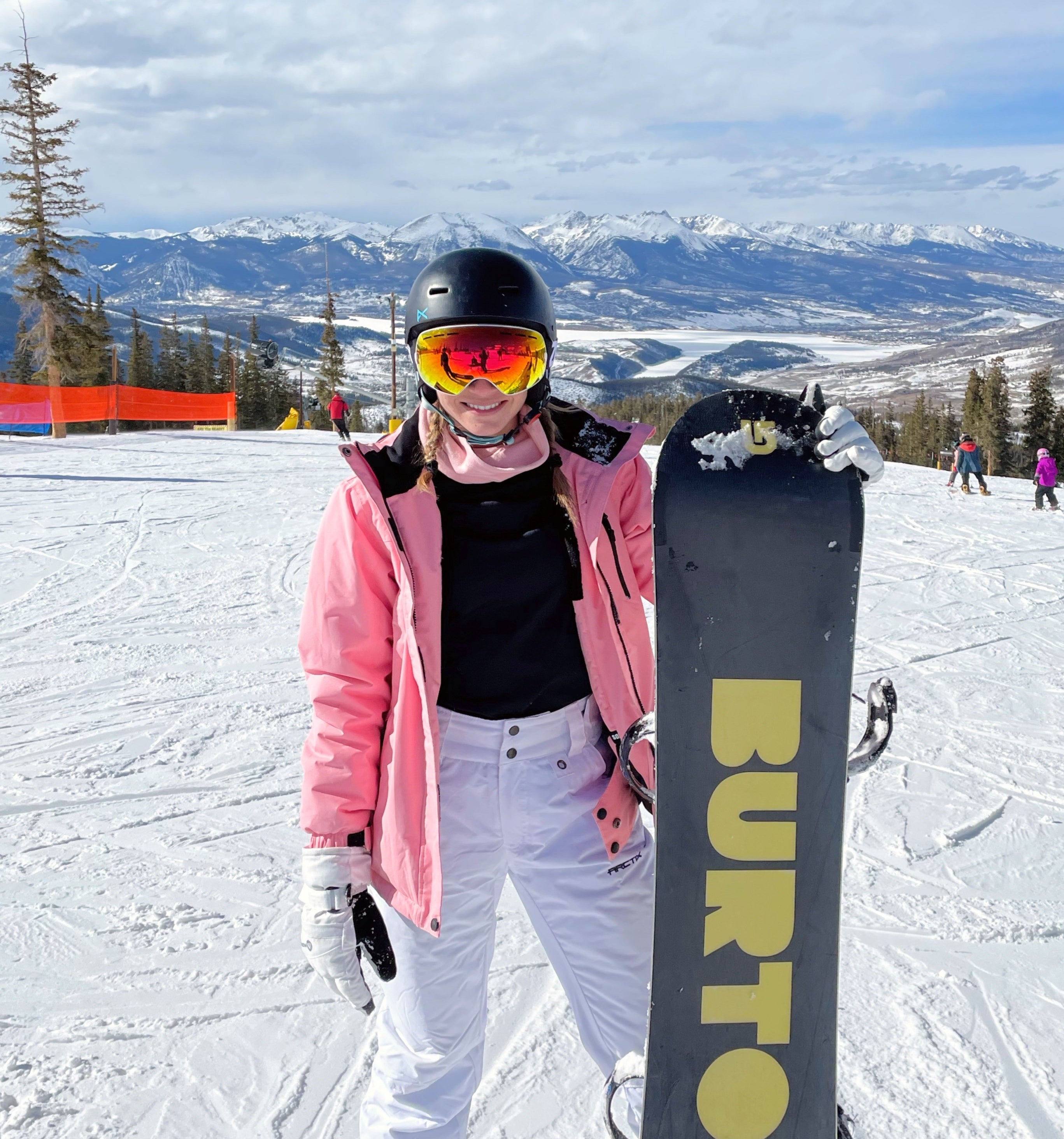 Reviewer out on the slopes in the white snowpants with snowboard