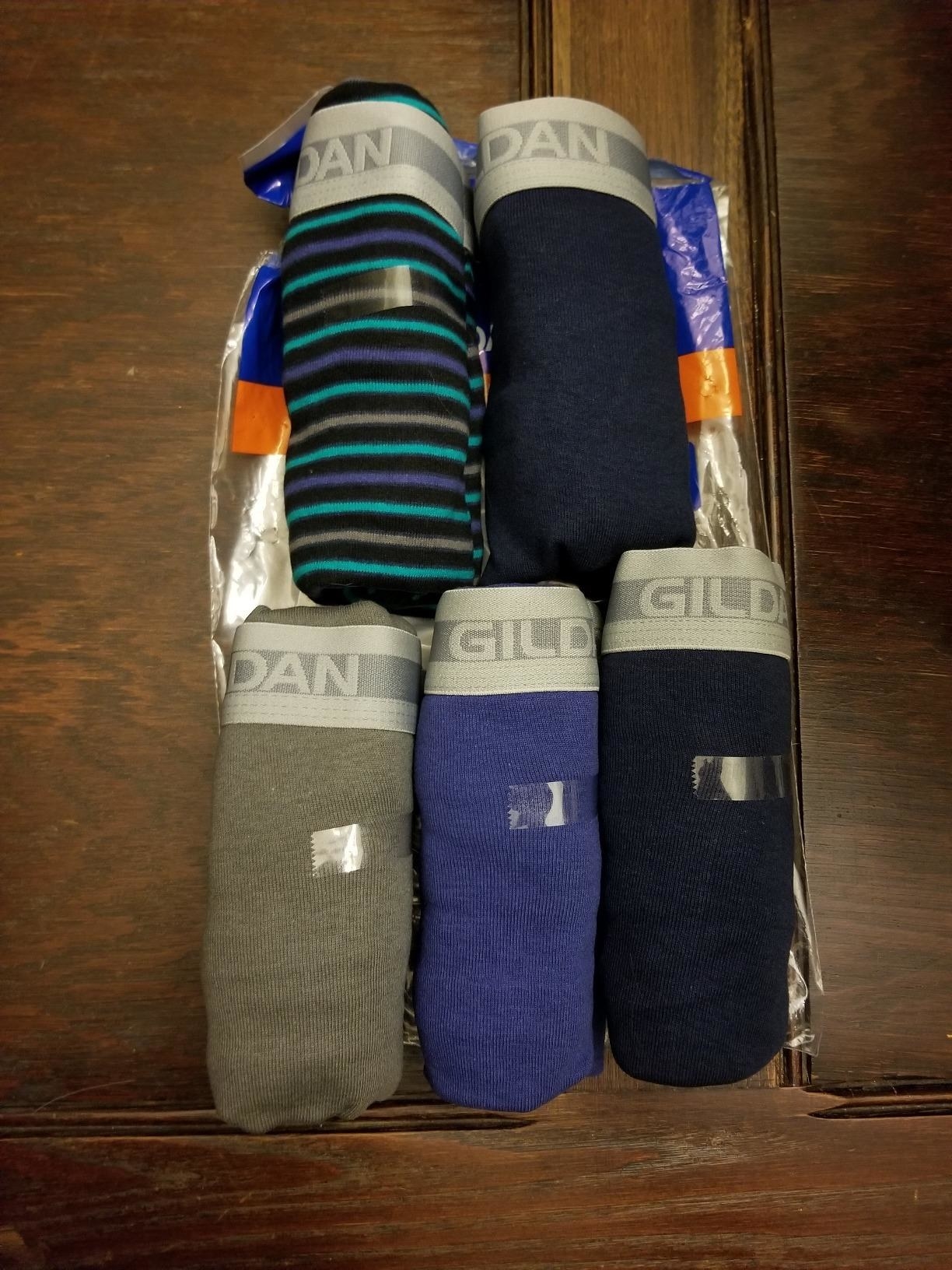 Reviewer&#x27;s photo of the rolled briefs in striped, dark blue, grey, light blue, and black