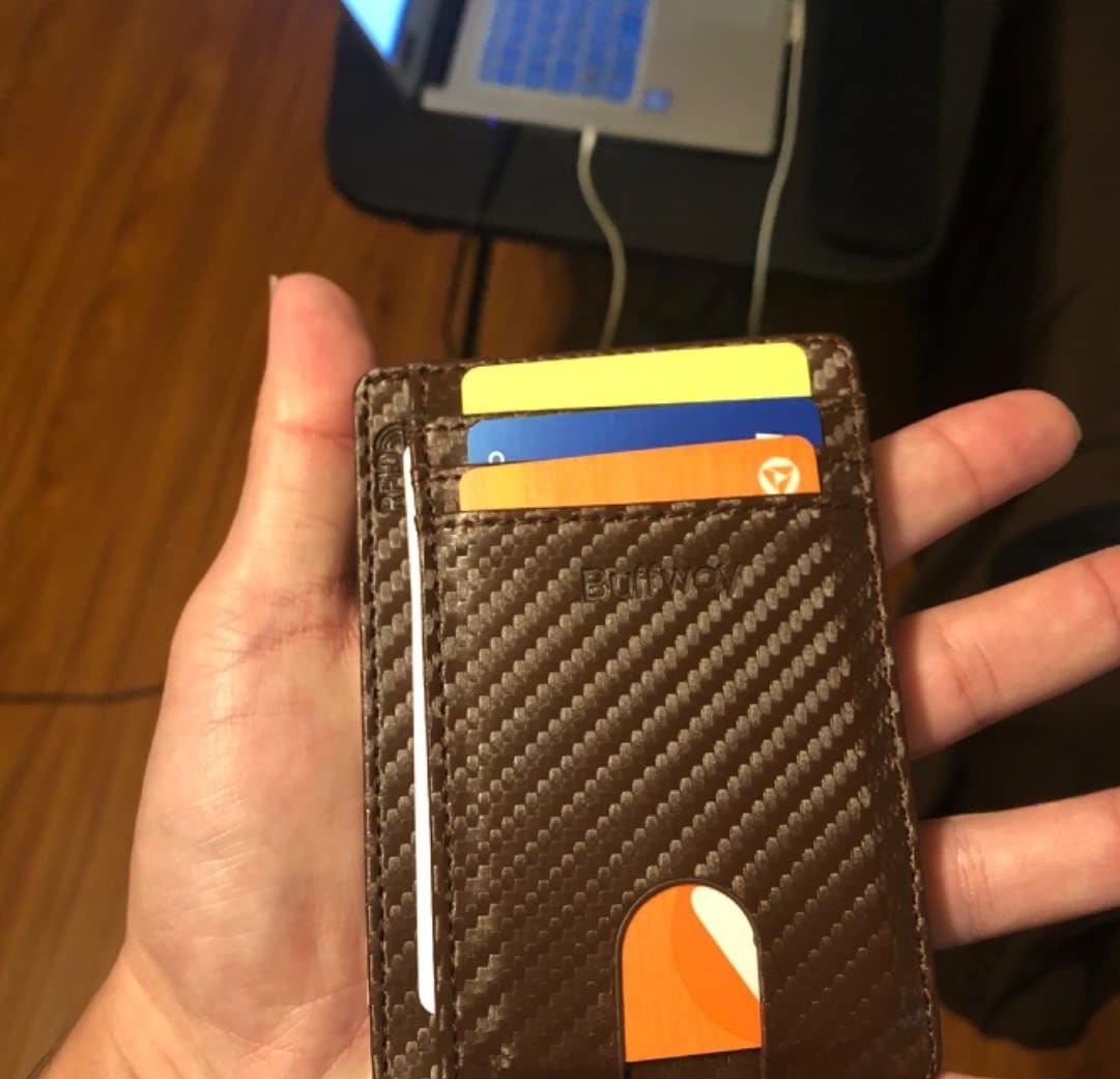 Reviewer holding the slim wallet in palm of hand with four cards stored inside