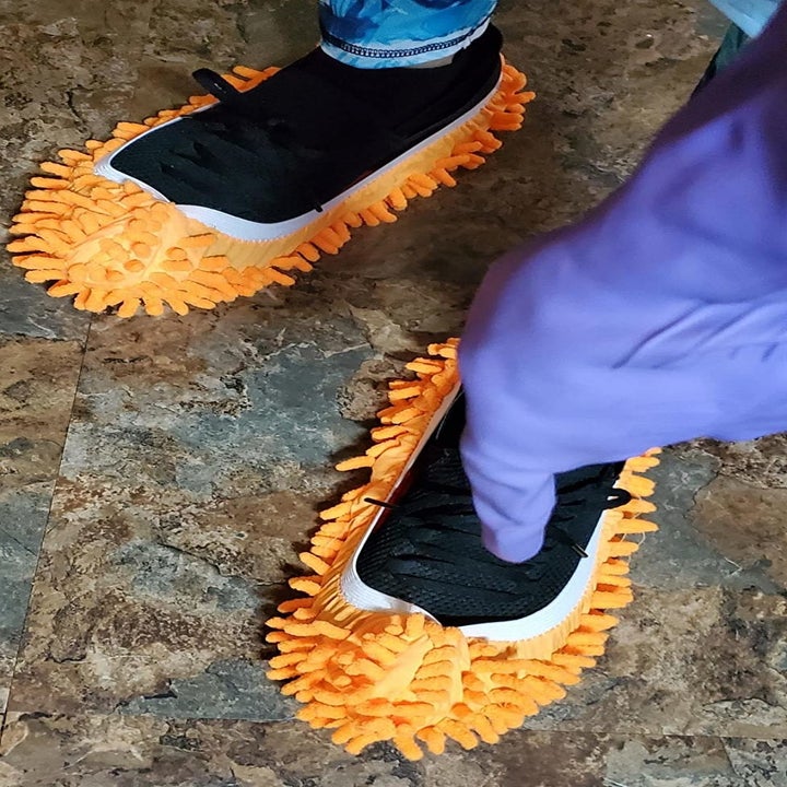reviewer's orange mop slippers over their shoes