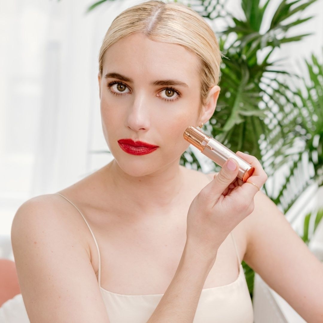 emma roberts using the tool on her cheek
