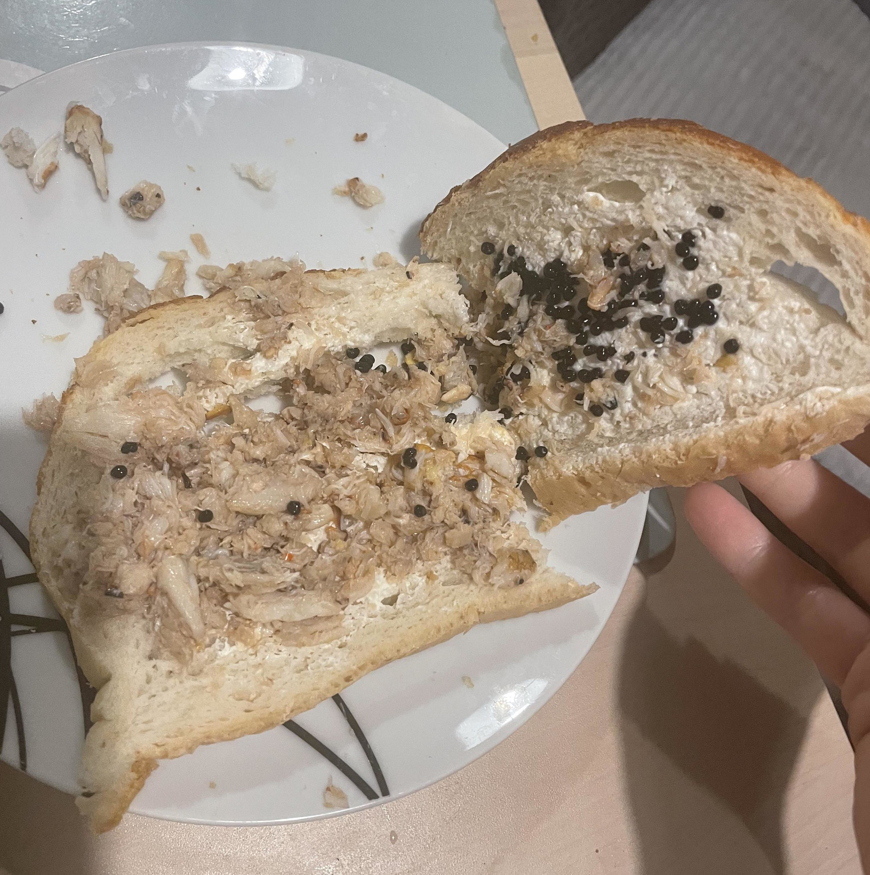 two slices of white bread with crab meat, caviar, and mayo in it