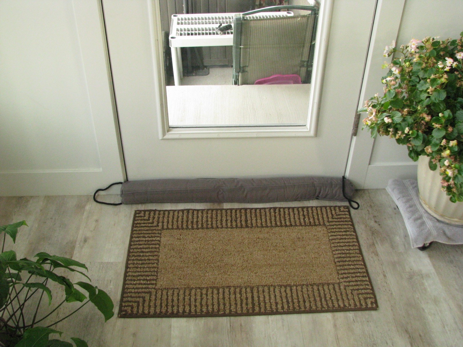 Reviewer image of draft stopper in front of a door with a glass panel