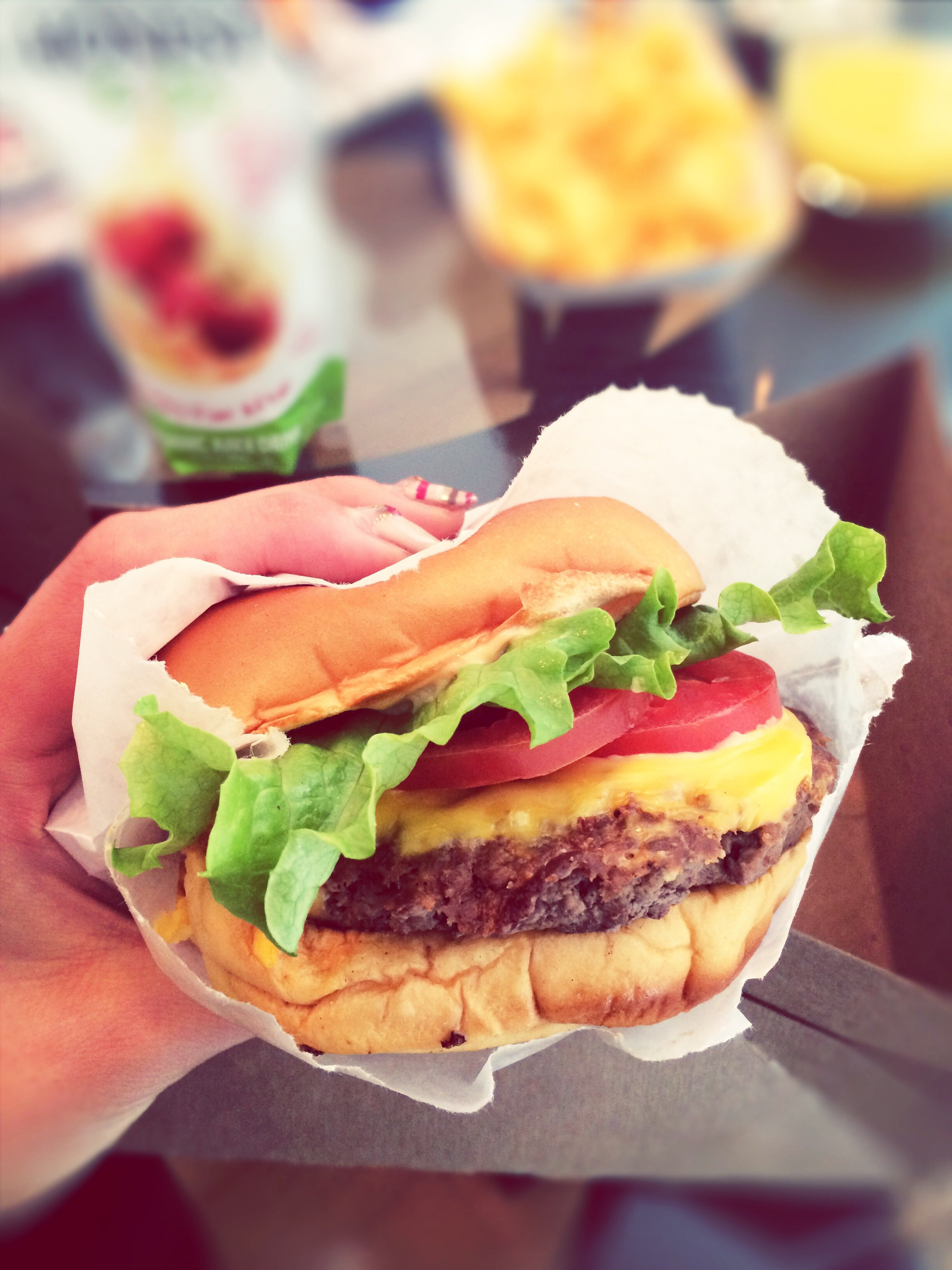 A hand holding a burger.