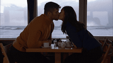 couple kissing across the table