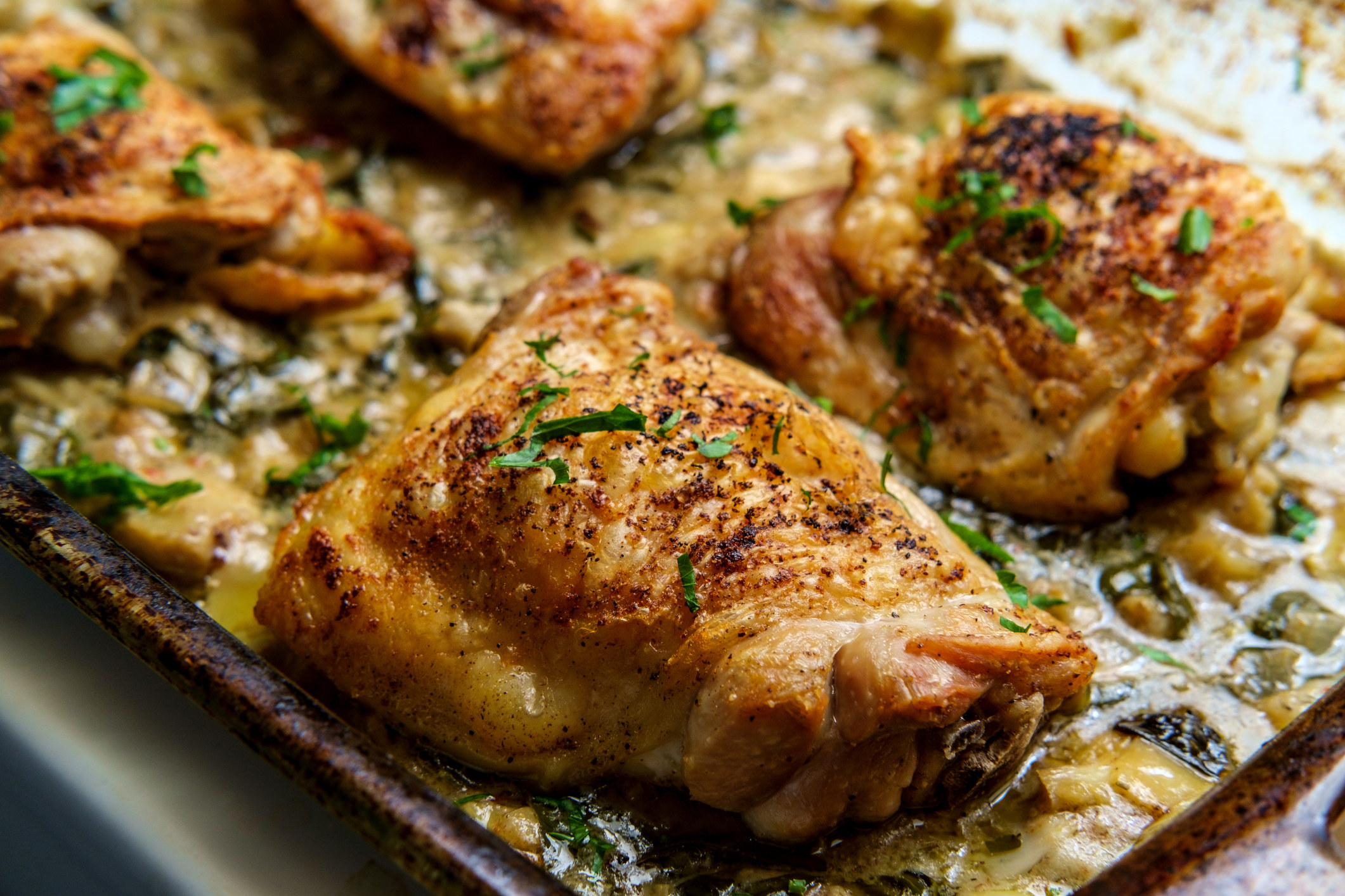 Chicken thighs on a sheet pan.