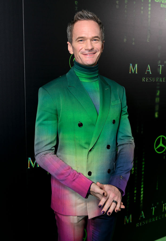 尼尔·戴一个定制的西装在彩虹色的颜色,深色指甲油矩阵复苏首映