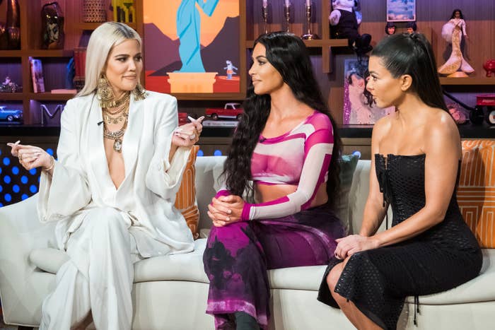 Khloe, Kim, and Kourtney Kardashian sitting on a couch