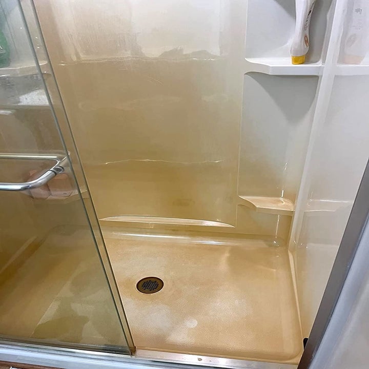 a reviewer's shower before, with red iron/rust stains all over the floor and walls