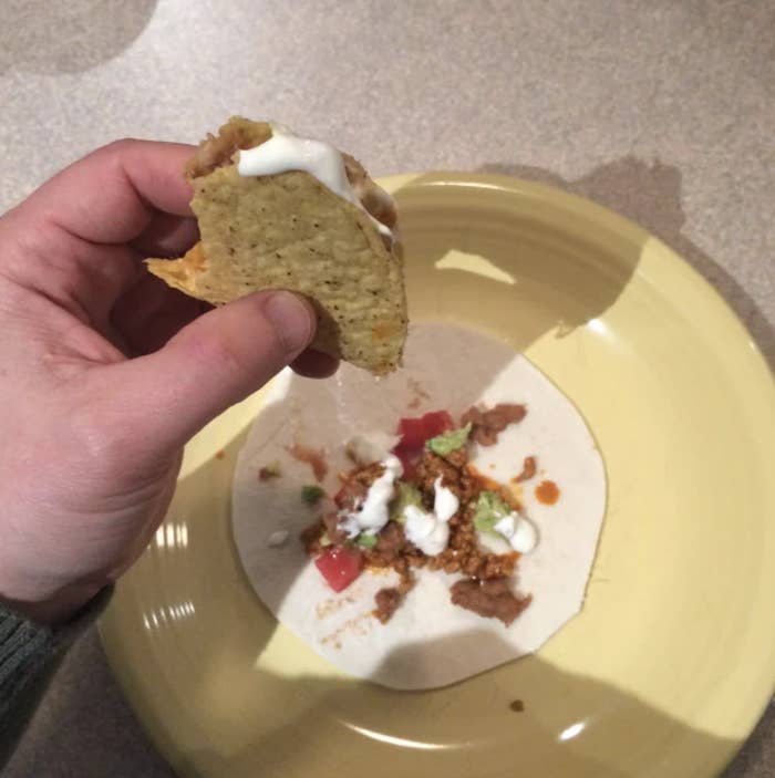 a hard-shell taco dripping over a soft shell, creating two tacos