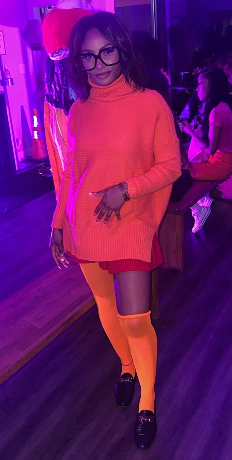 a reviewer wearing the orange sweater with orange tights