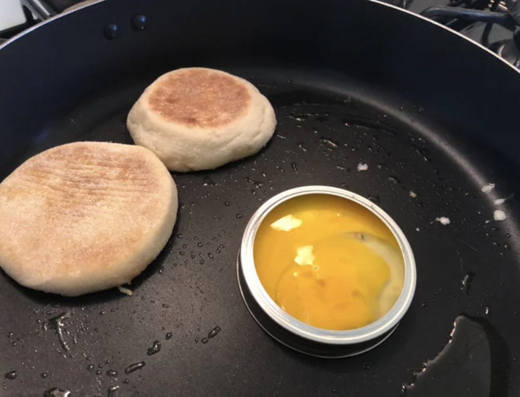 English muffin and an egg in a mason jar lid on a pan