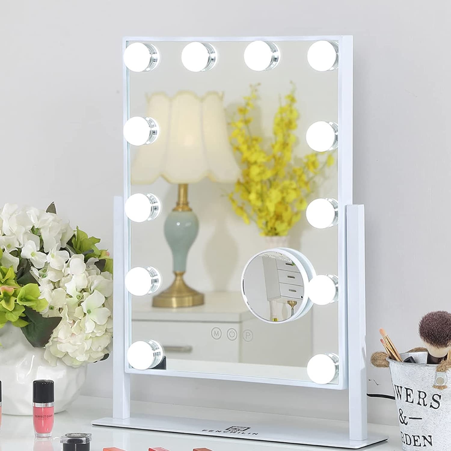 The mirror on a vanity surrounded by makeup and beauty tools