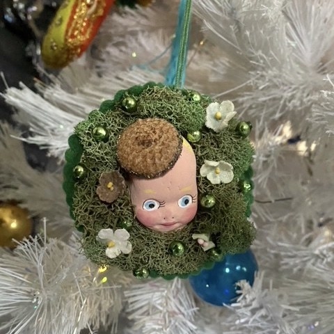 spooky baby head coming out of a wreath